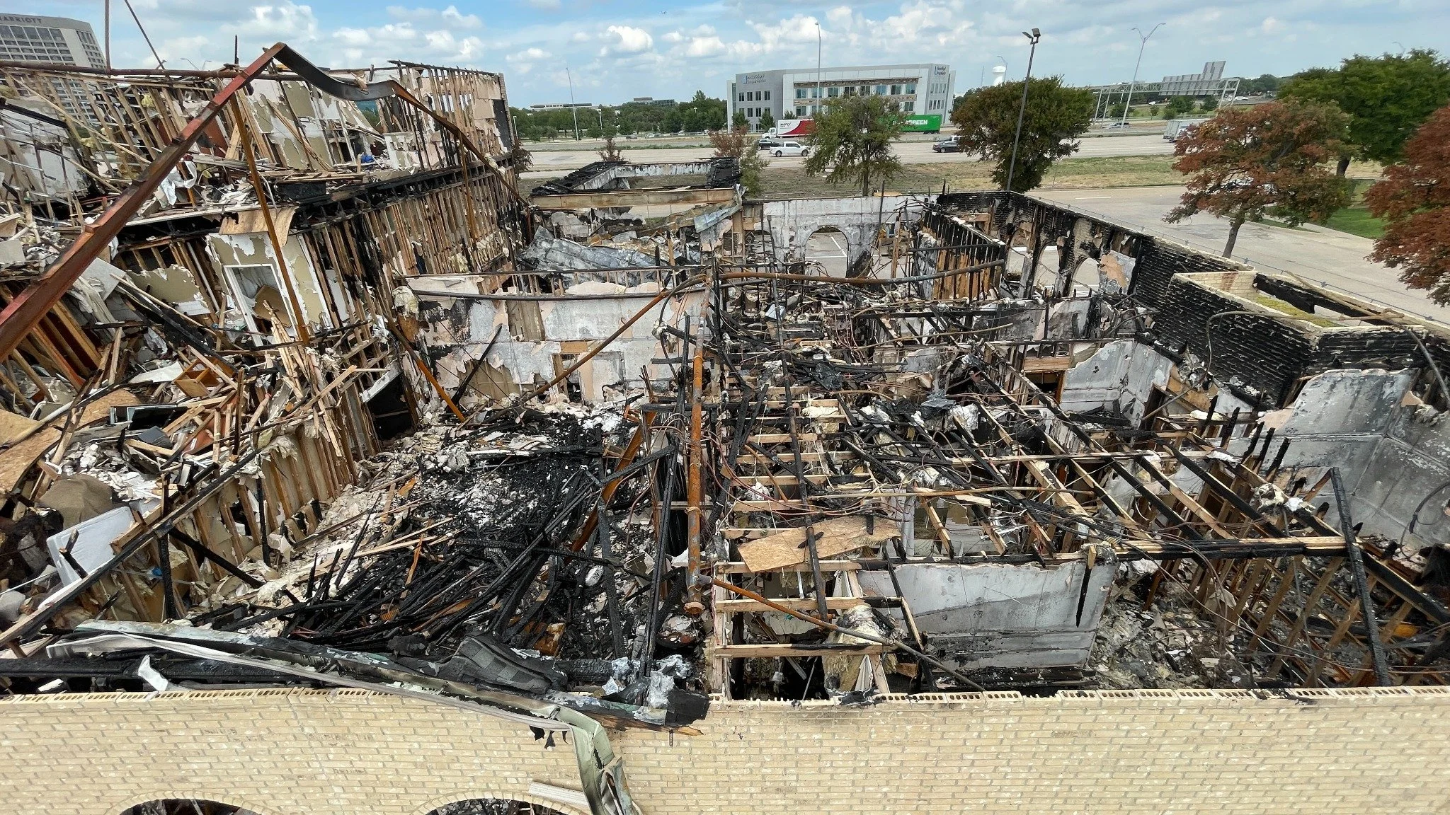 Elevated overview of extensive fire damage across a complex structure