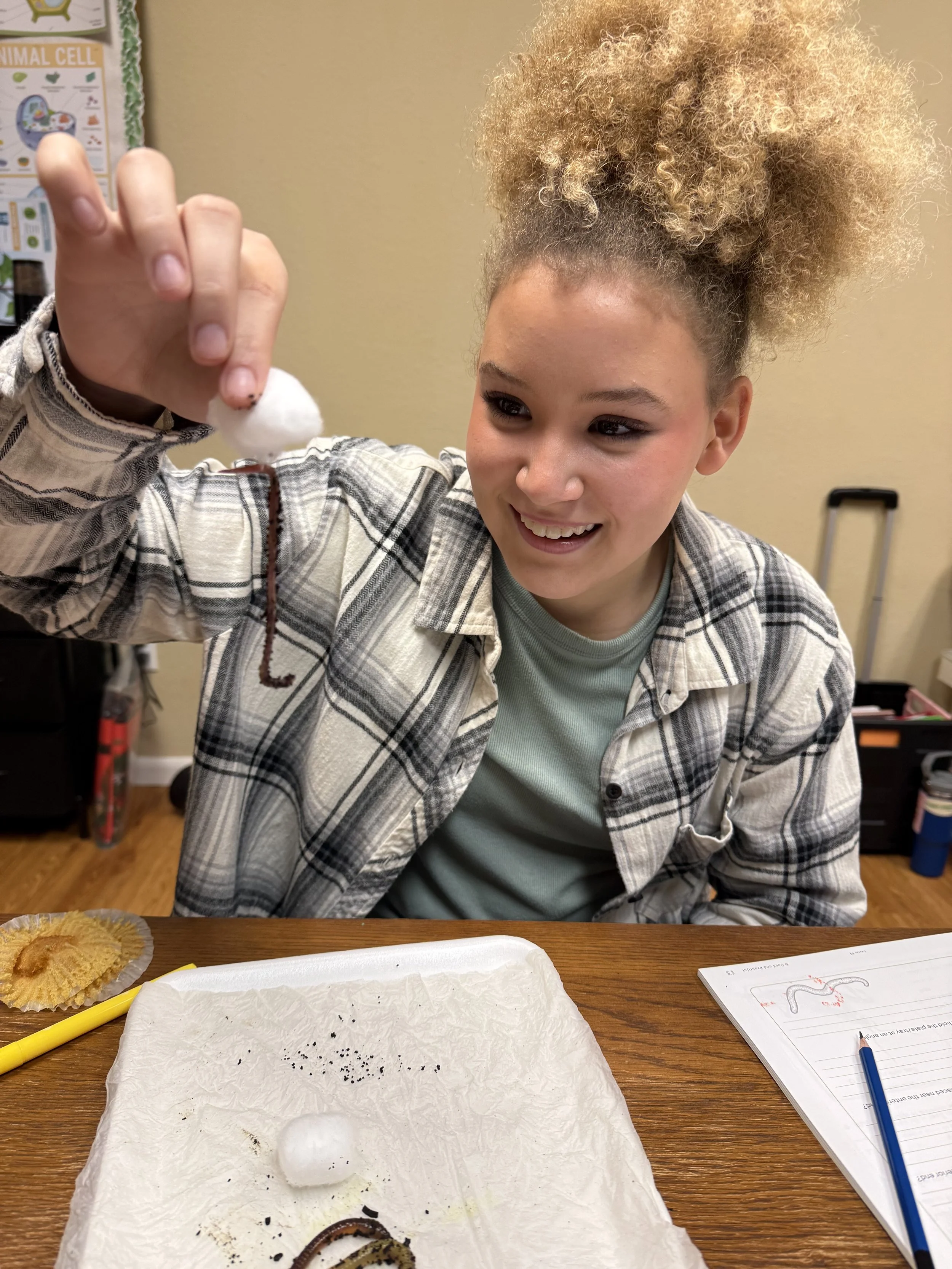 Student holding worm in science class