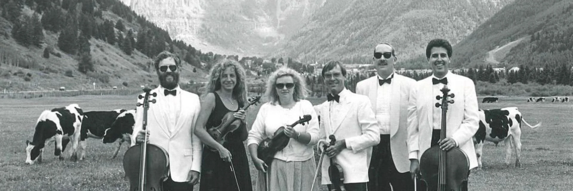 Telluride Chamber Music's early years — musicians in white tuxedos with cellos and violins, in a pasture below the Box Canyon
