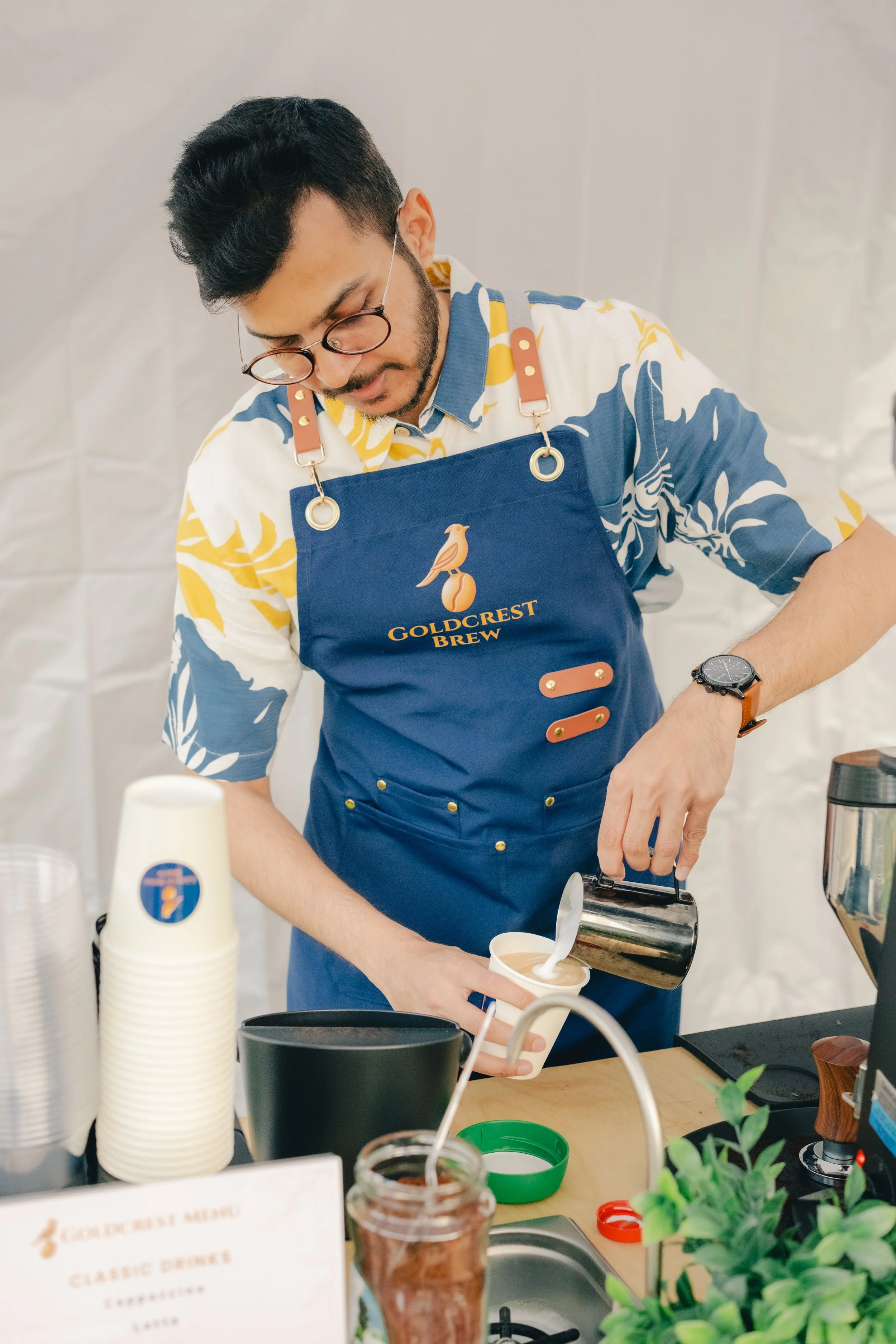 Goldcrest Brew founder Zain pouring latte art at a Bay Area coffee catering event