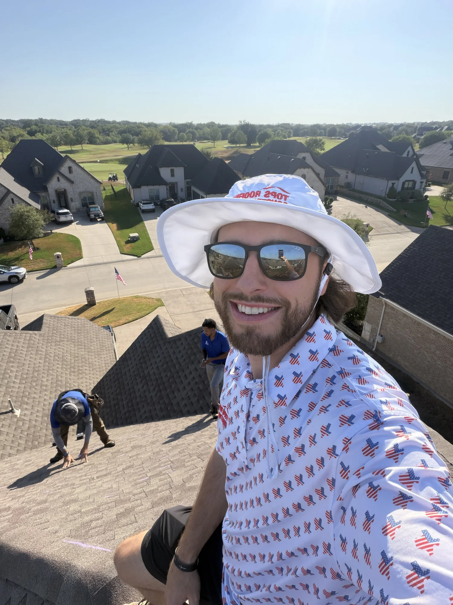 Client-supplied photograph of roofing crew members working on a roof
