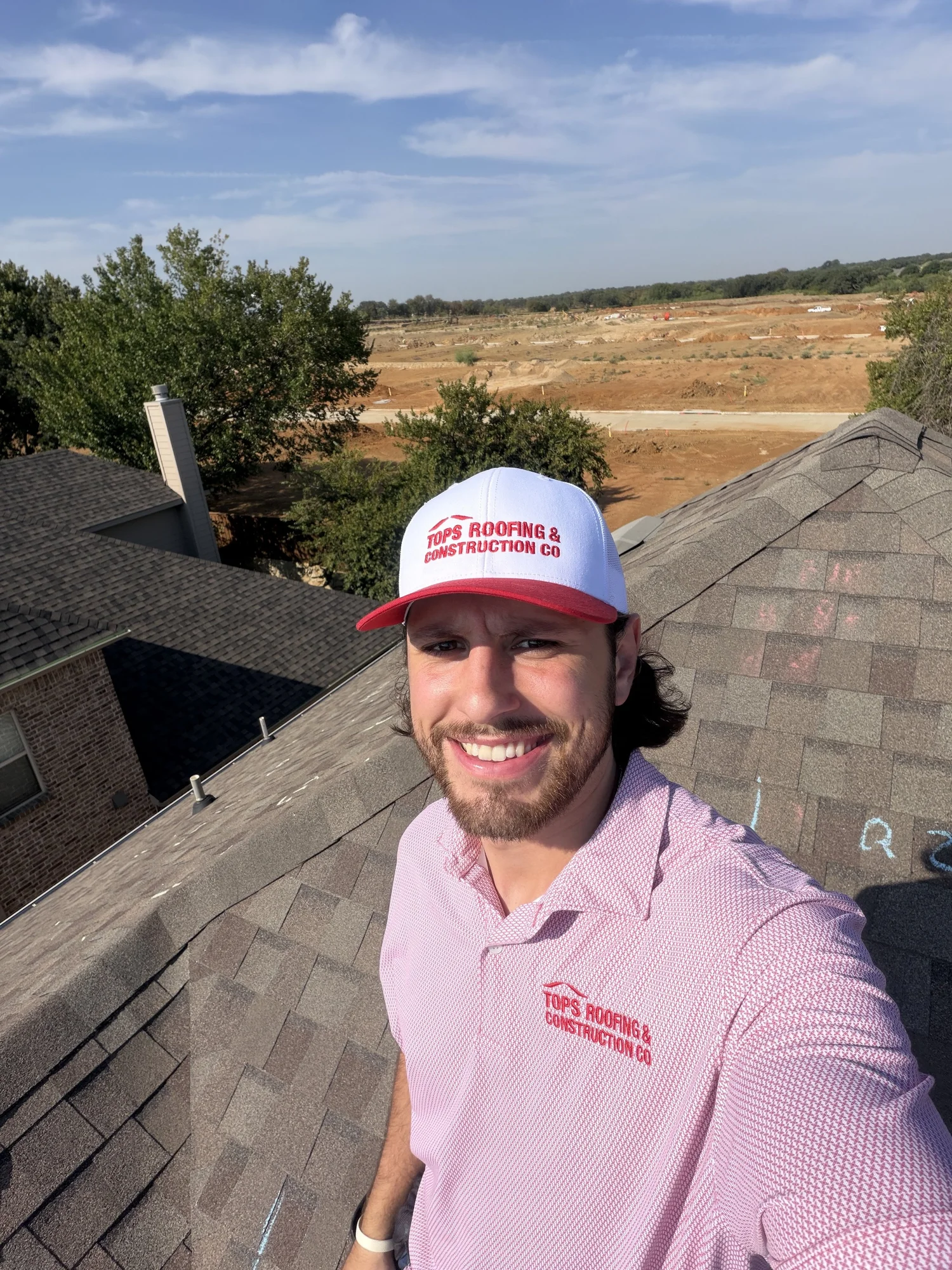 Trevor Dauzat on a residential roof wearing TOPS Roofing apparel