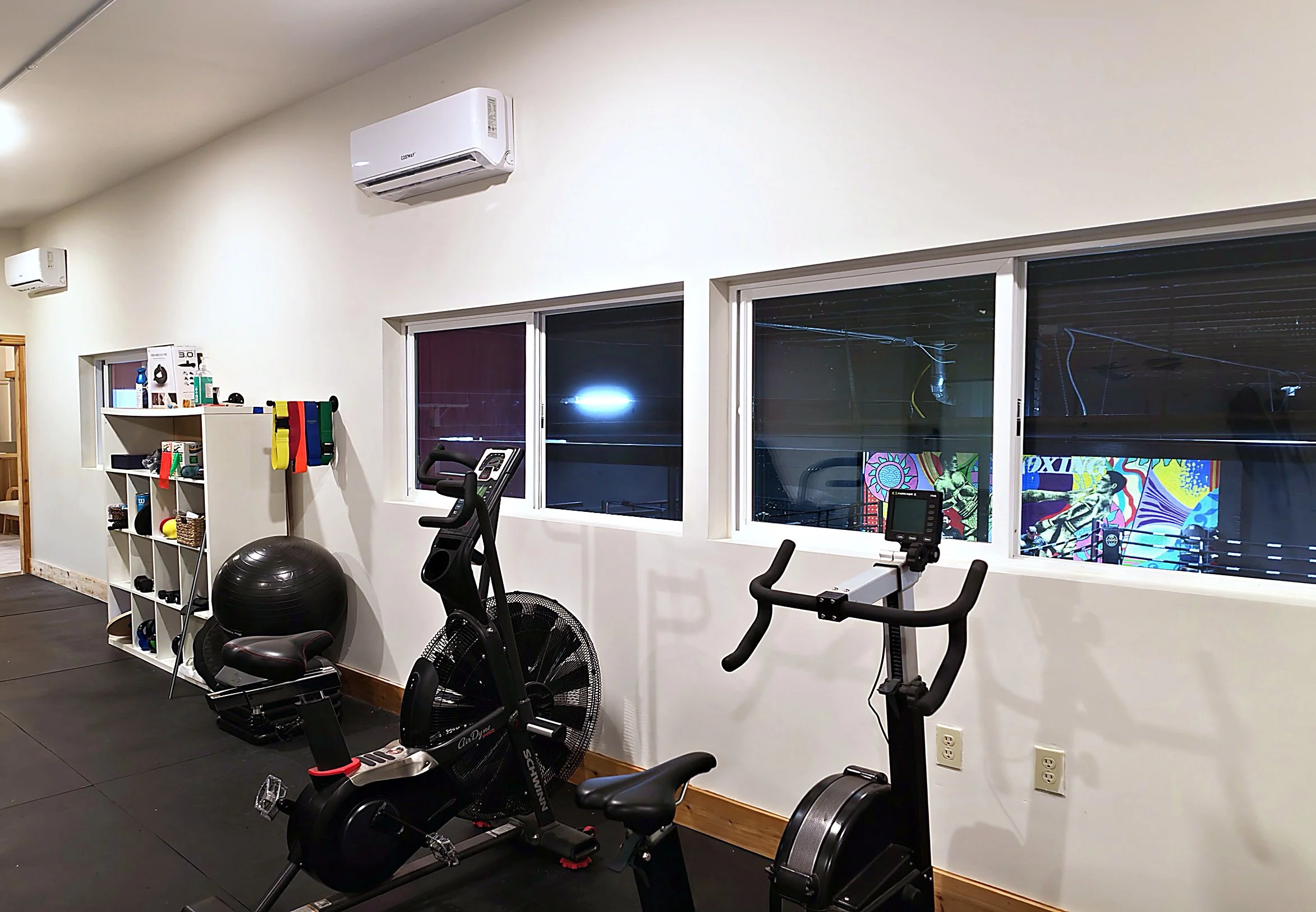 Warm-up area with exercise bikes and windows looking onto the training floor at Root Physical Therapy Seattle