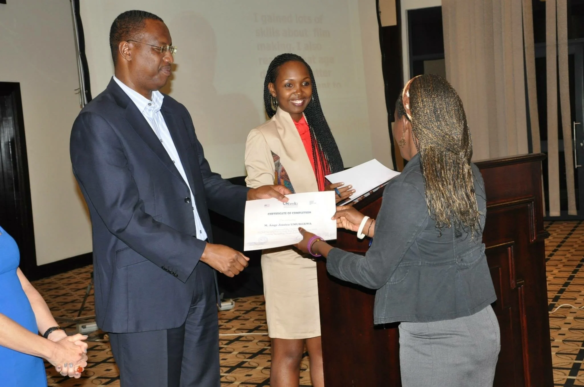 A workshop graduate receives her certificate of completion from a Rwandan government official at the closing ceremony, Kigali Serena Hotel, 2013.
