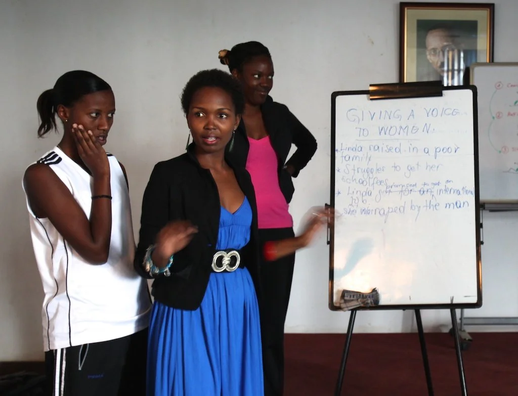 Participants developing a story on a flip chart headed 'Giving a Voice to Women' during the Women's Potential in Cinema workshop, Kigali, Rwanda, 2013.