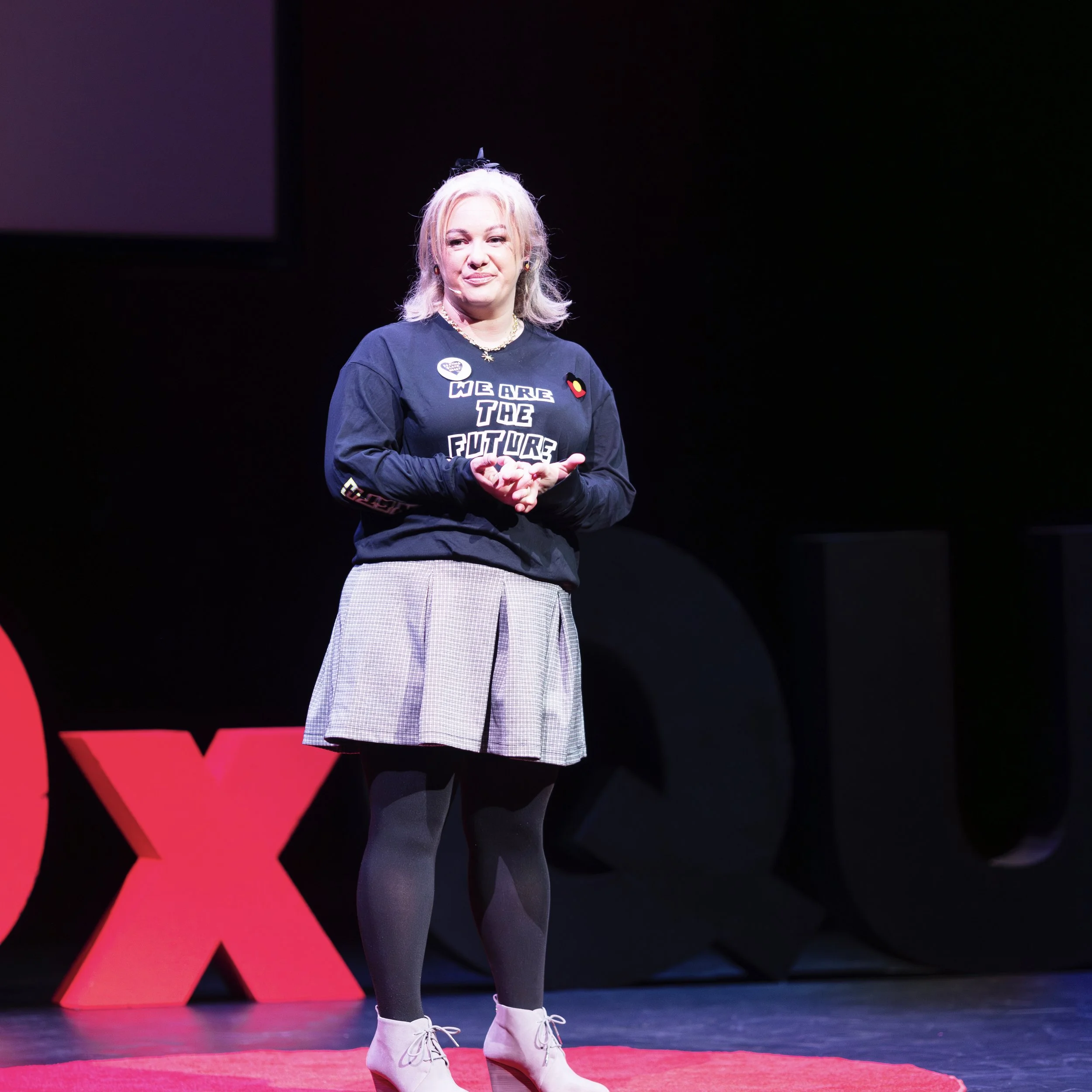 Jade Robertson speaking on the TEDx QUT stage