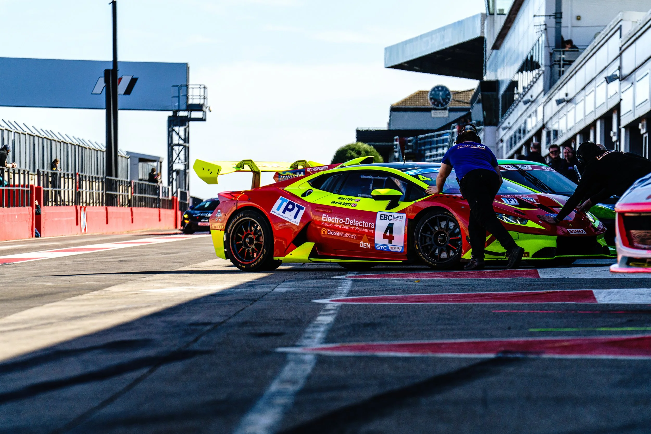 Race team moving cars through the pit lane