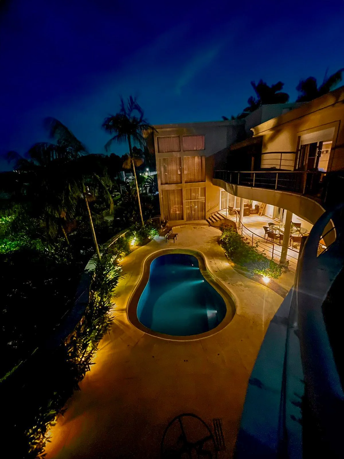 Vista noturna da piscina e área externa