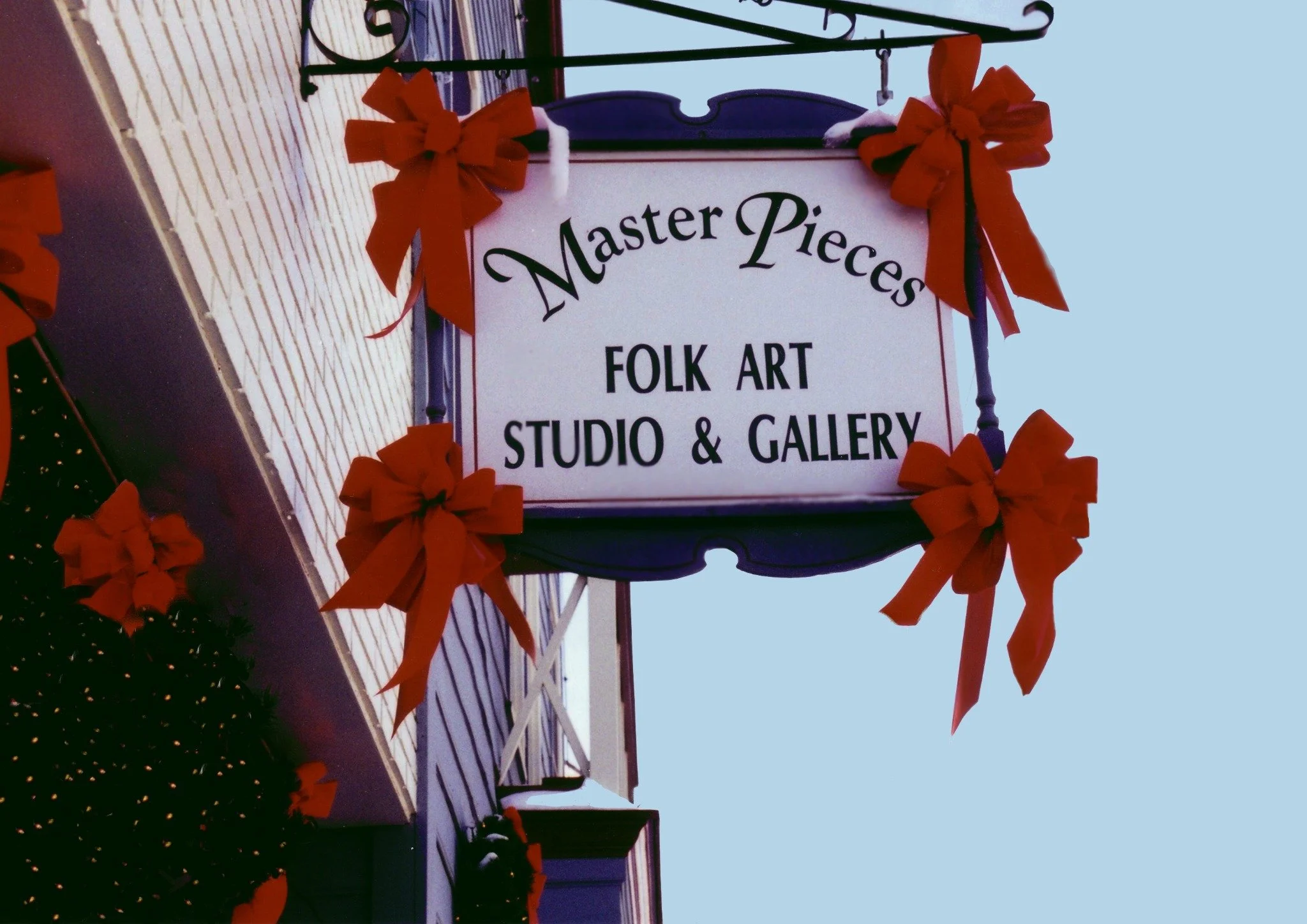 The Master Pieces sign decorated with red Christmas bows.