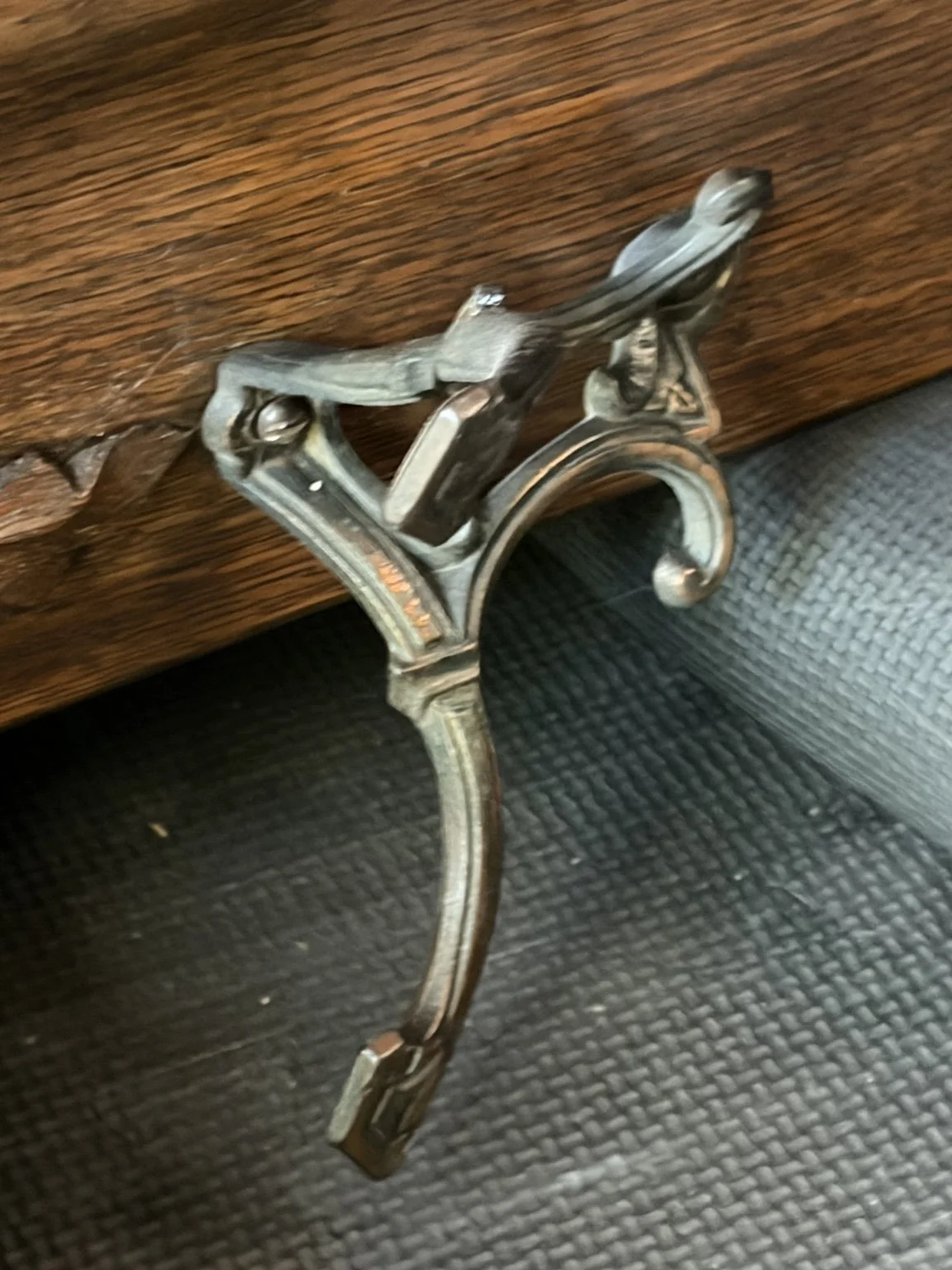 Ornate metal hook and wood grain on the family’s entryway piece