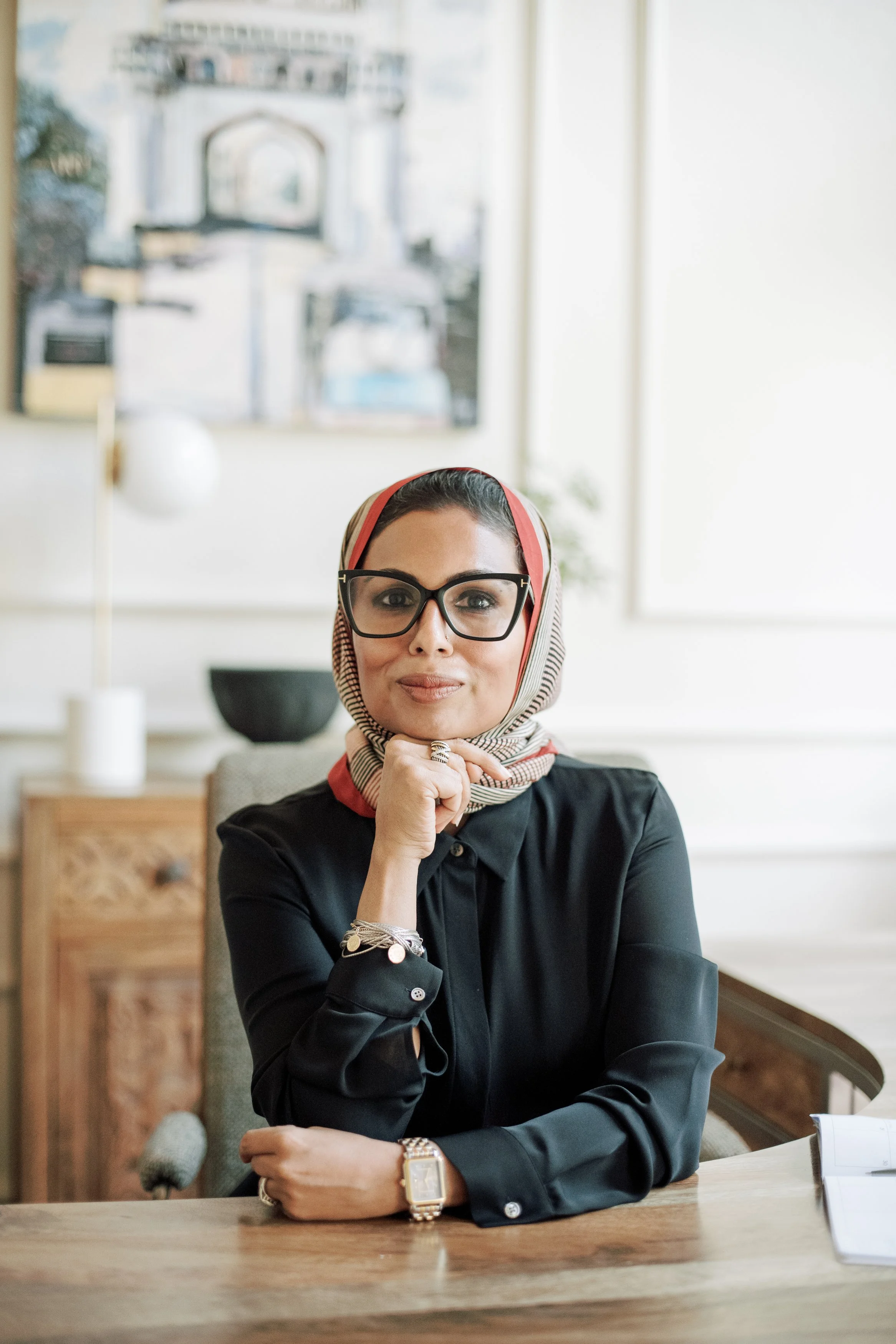 Dr. Mariya Farooqi seated at a wooden table, looking at the camera
