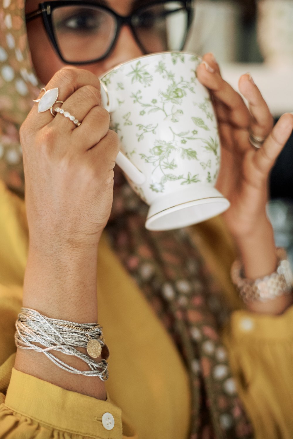 Dr. Farooqi sipping from a floral teacup