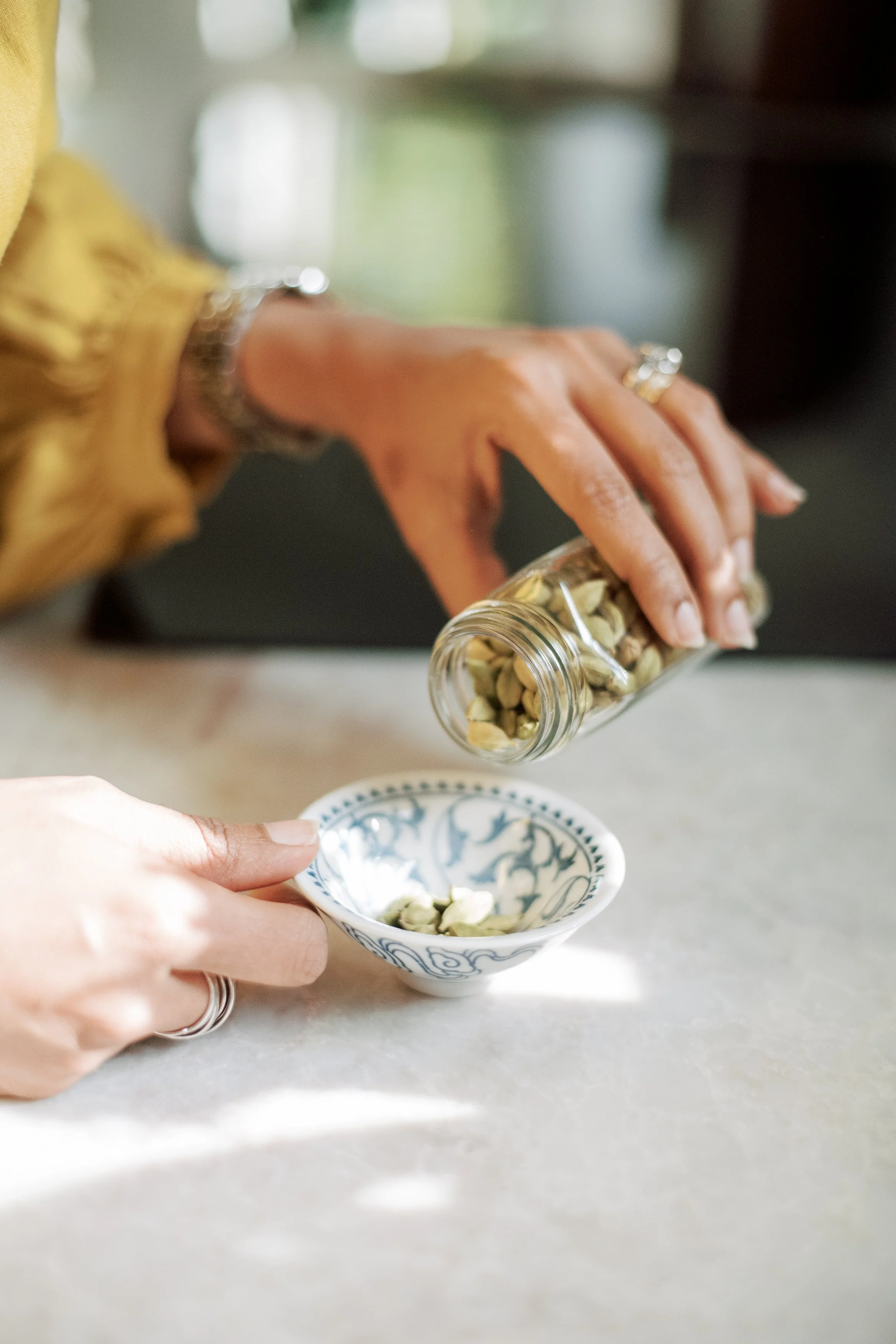Dr. Mariya Farooqi pouring dried herbs into a small bowl