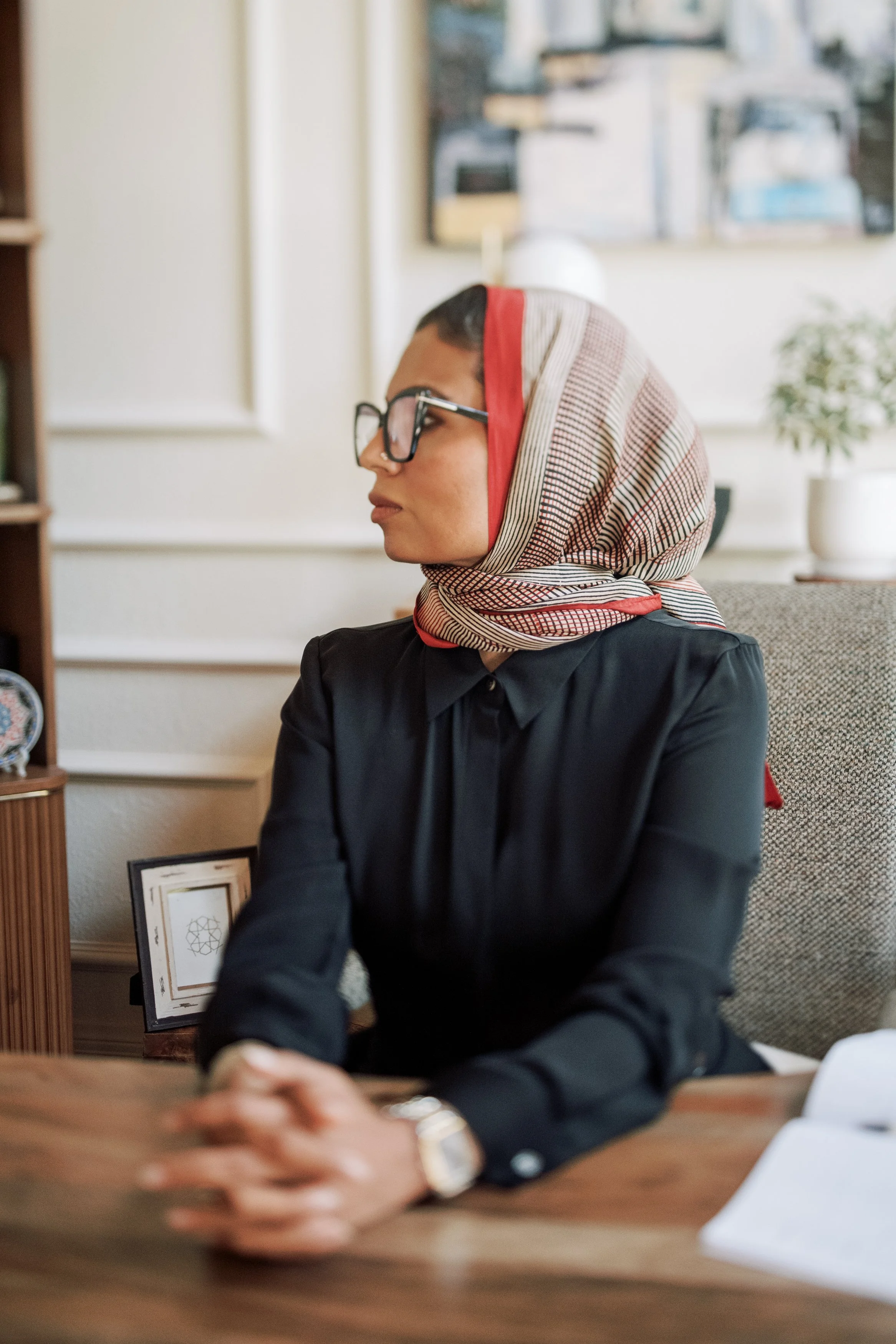Dr. Farooqi seated at her desk, looking out the window