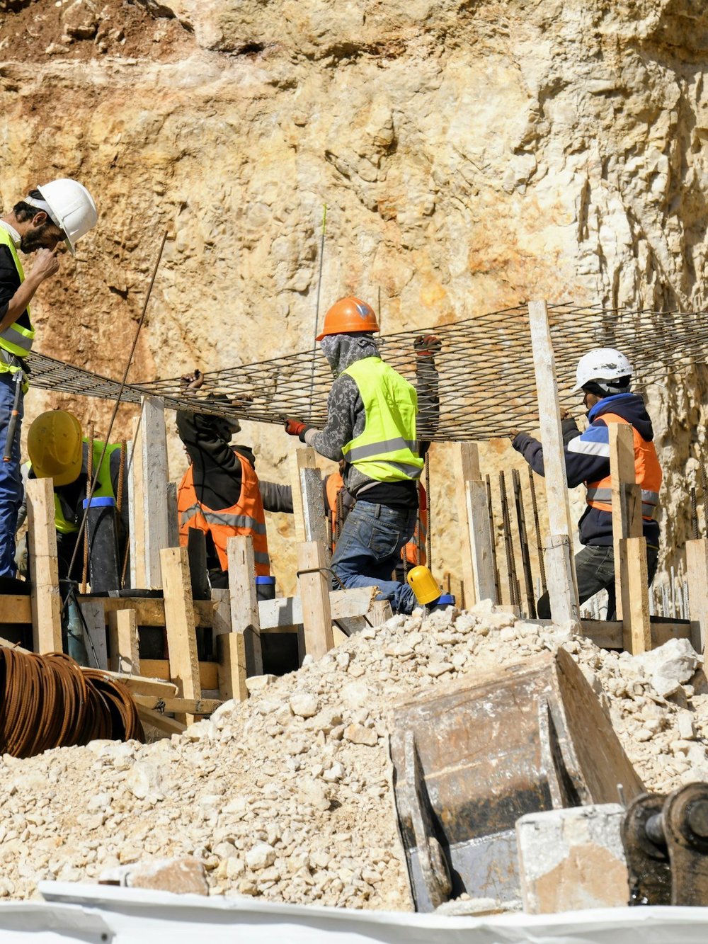 Bauarbeiter in Warnkleidung verlegen Bewehrungsstahl auf einer Baustelle