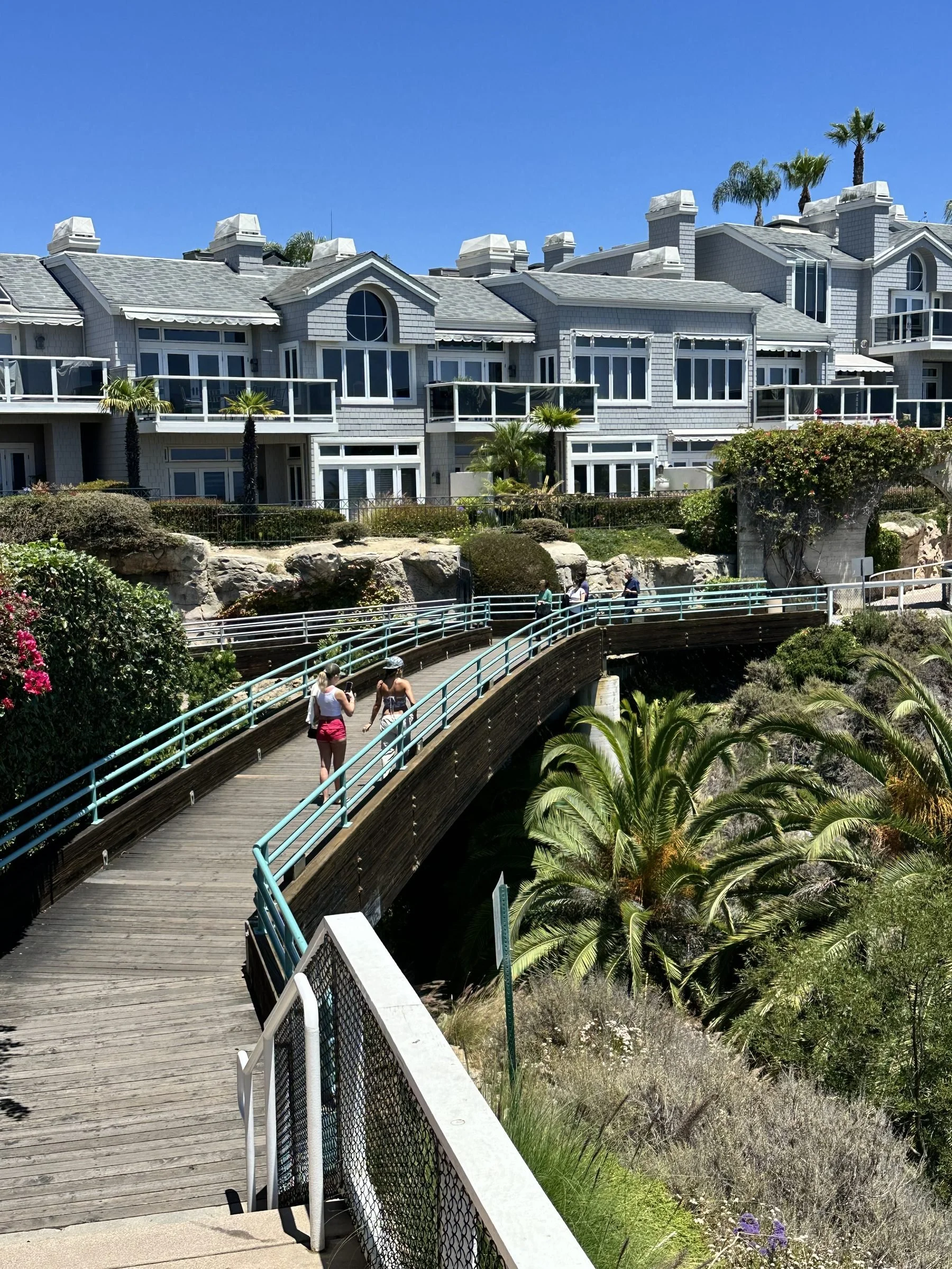 A coastal boardwalk trail leading past shingle-style residences in Dana Point
