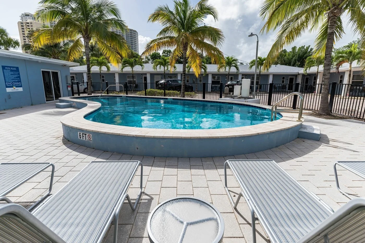 Seascape Apartments pool deck with lounge chairs and palms