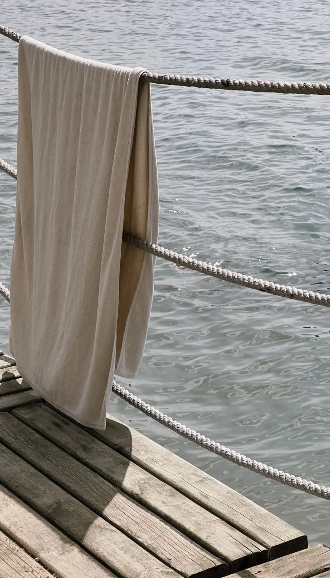Towel drying on a dock railing above the water
