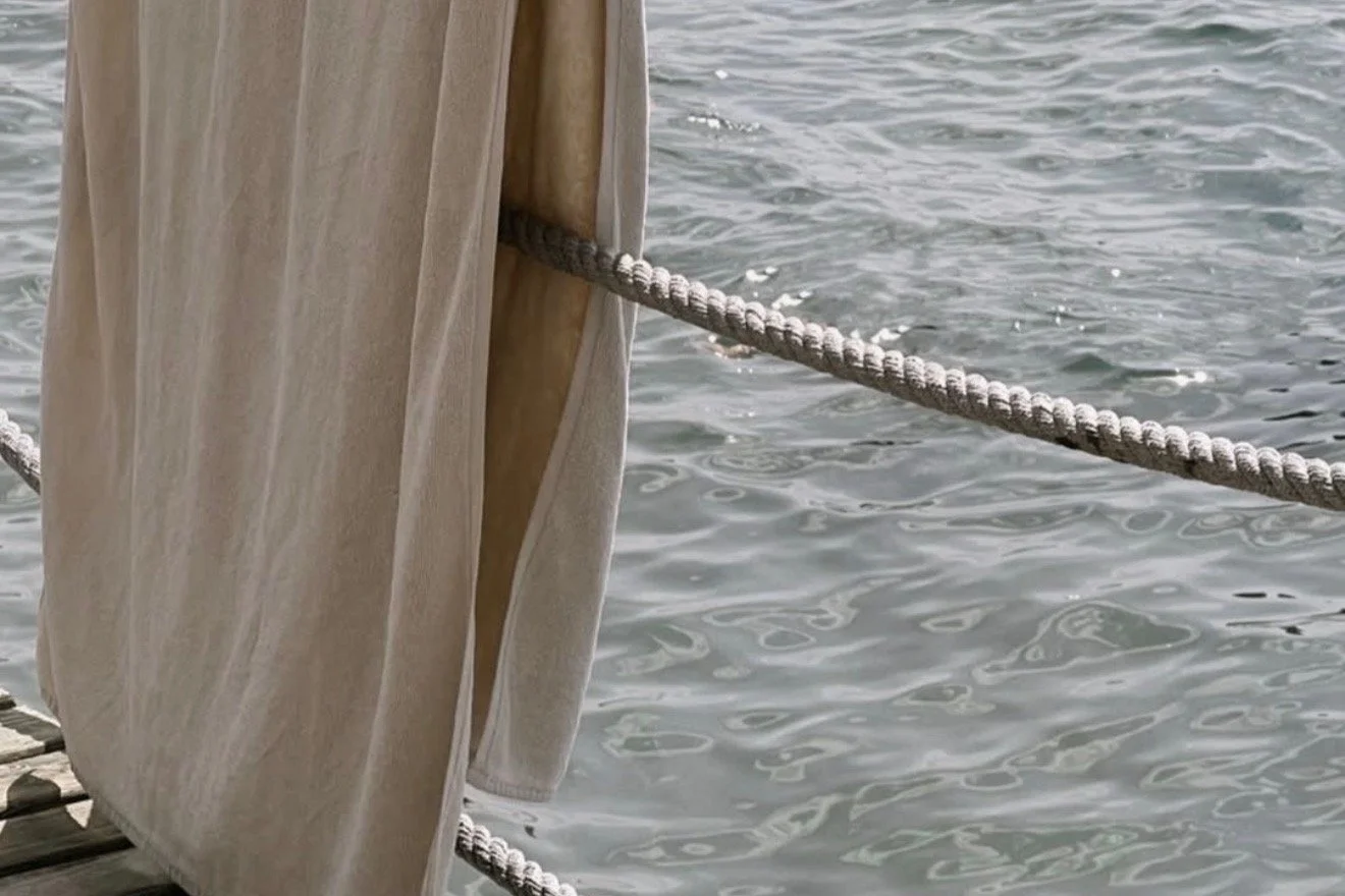 Towel drying on a dock railing above the water