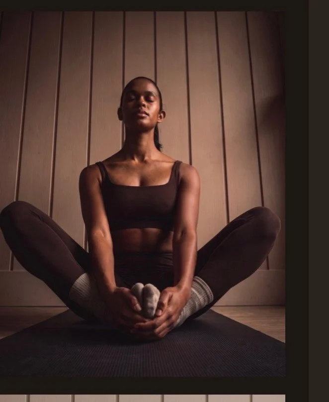 Woman stretching in a seated forward fold, editorial recovery photography
