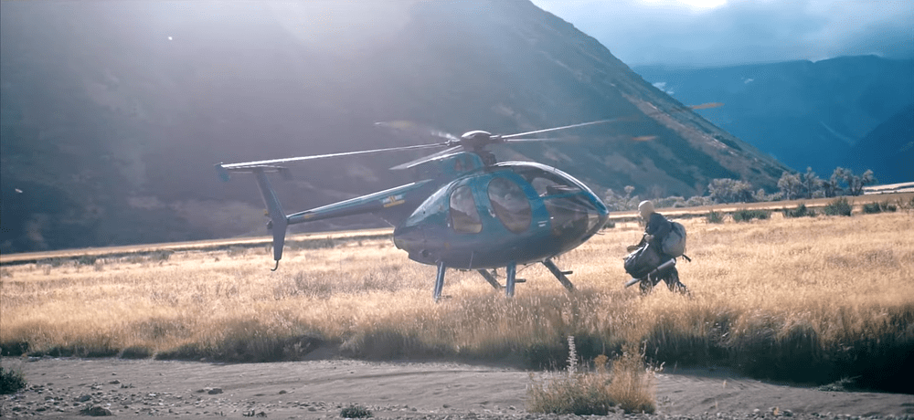 An angler beside a helicopter in a South Island mountain valley