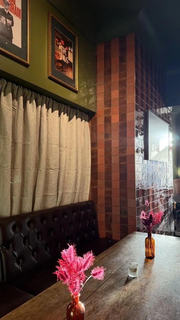 Buttoned leather booth and tiled wall in the Snug