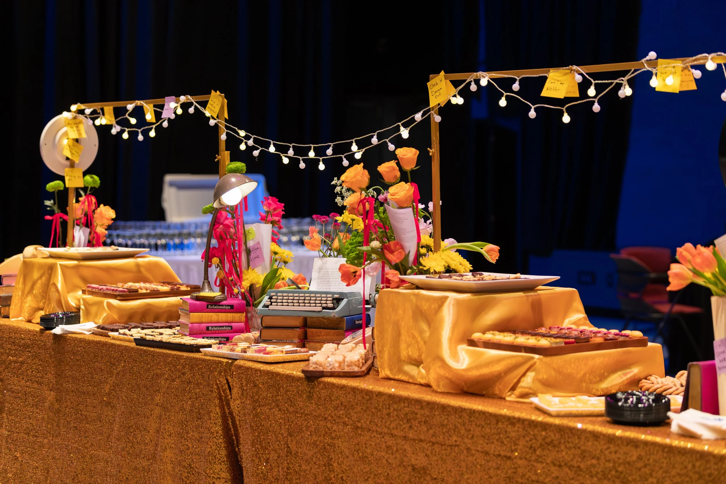 Opening night display for the musical 9 to 5 at Riverside Theatre, with a typewriter, string lights and marigold flowers