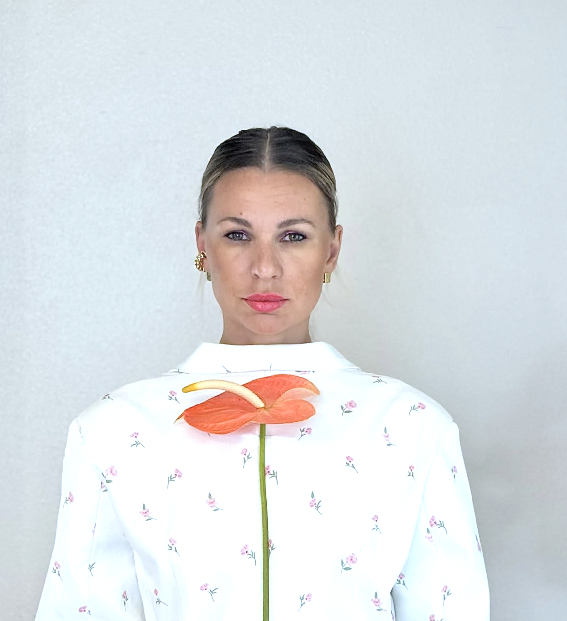 Yuliia Hyatt, floral designer and owner of Yuliia Flowers, holding a single orange anthurium