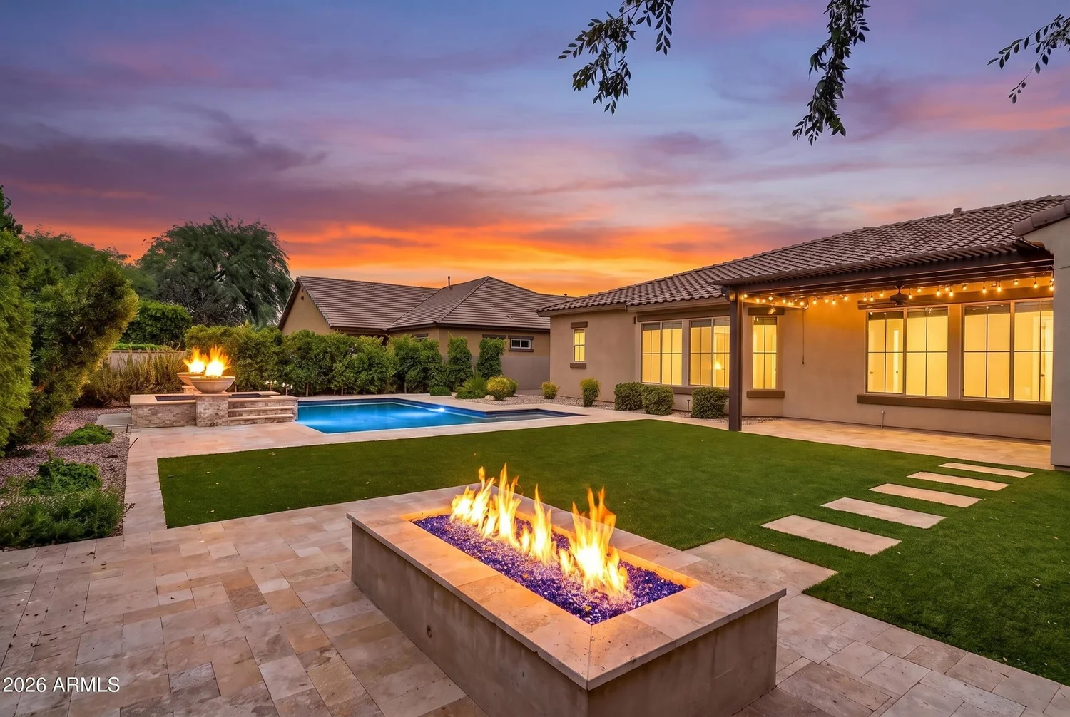 Backyard fire feature and pool at sunset at a Southeast Valley luxury home