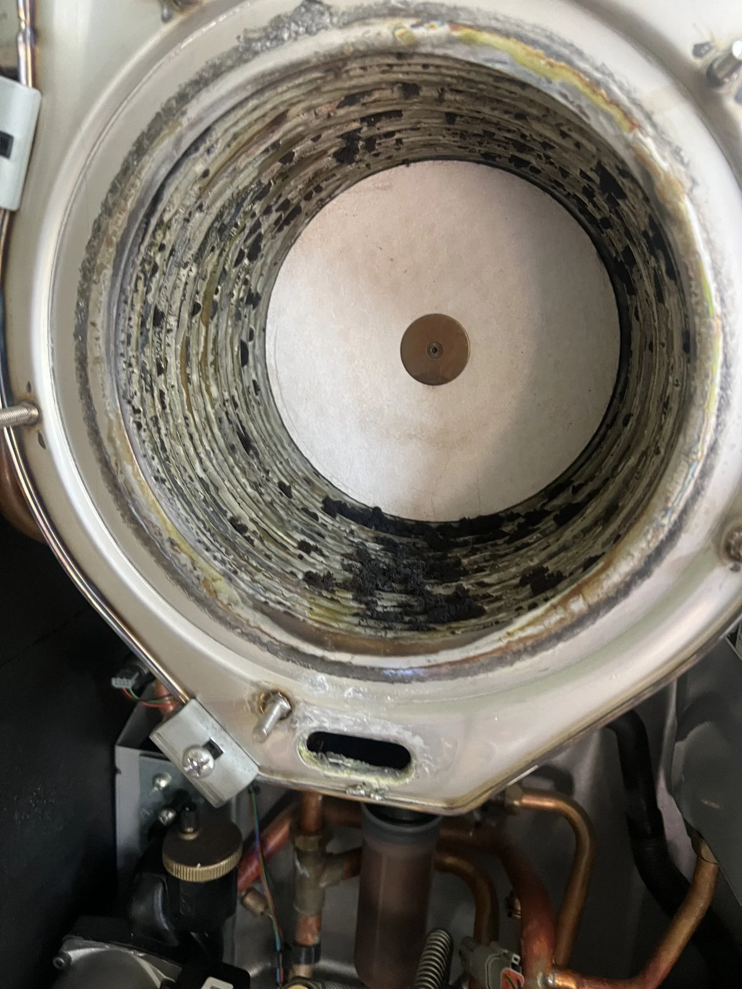 Combustion deposits found on the heat exchanger coils during a boiler service, before cleaning