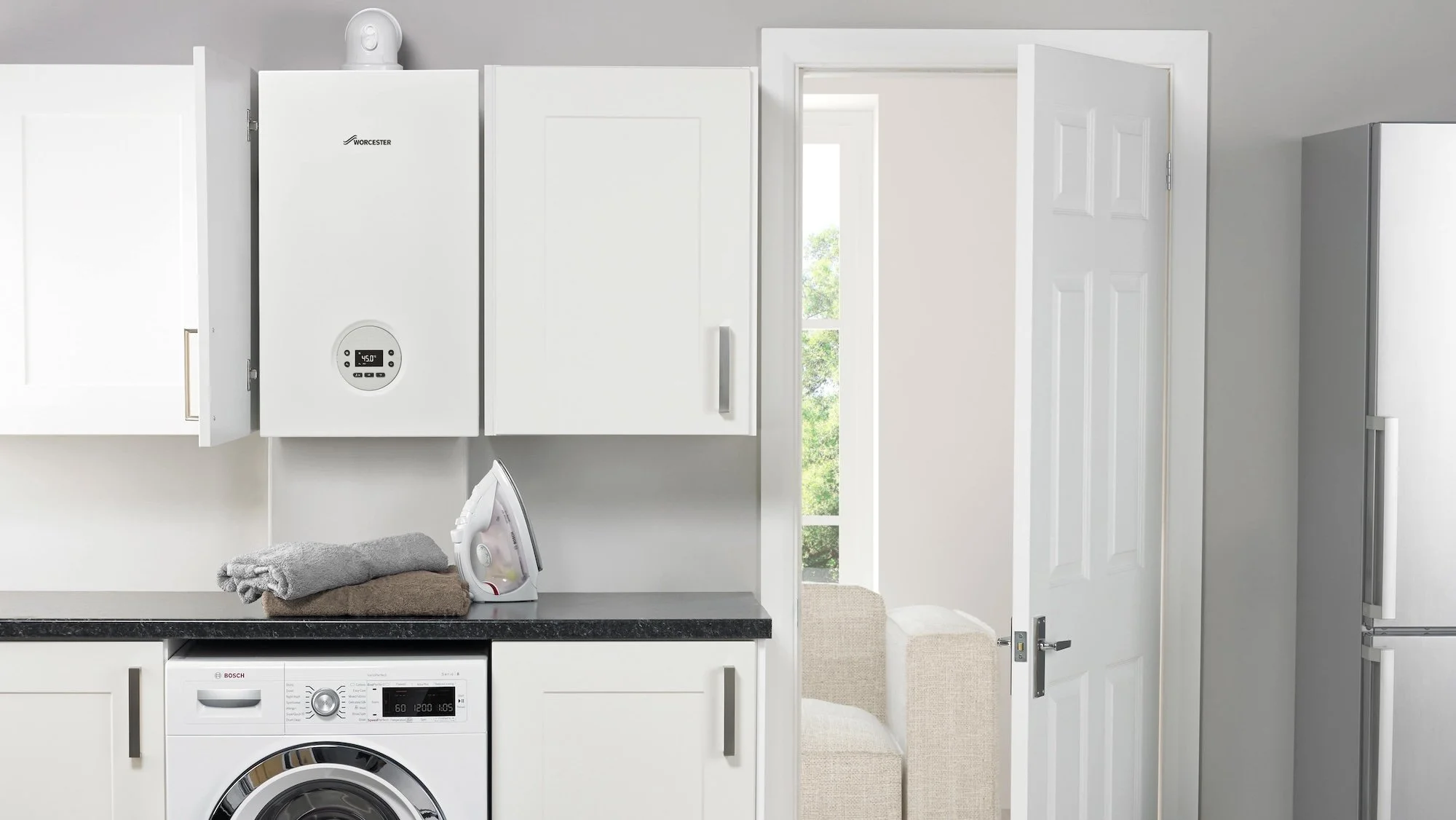 Worcester Greenstar combi boiler mounted between cupboards in a utility room