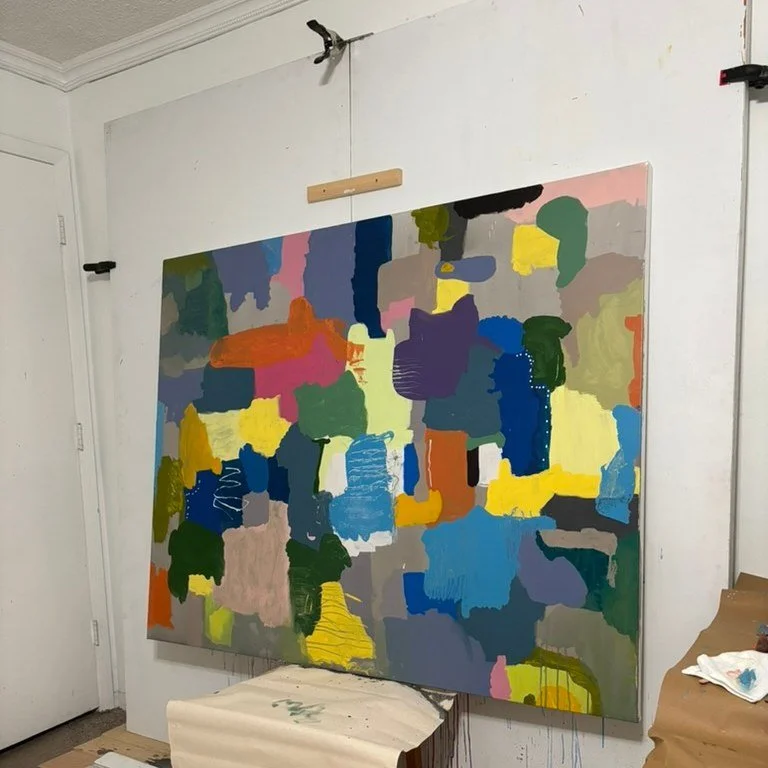 A large colorful abstract painting by Marcus Bacher on his studio wall.
