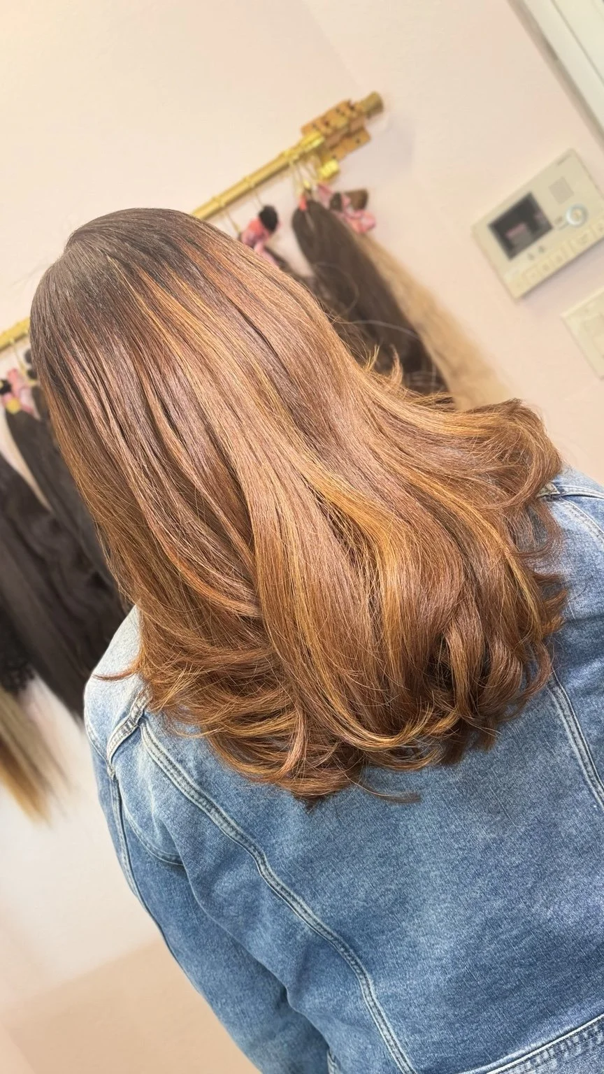 Dimensional caramel and brunette hair finished with soft layers at Hairapy Studio
