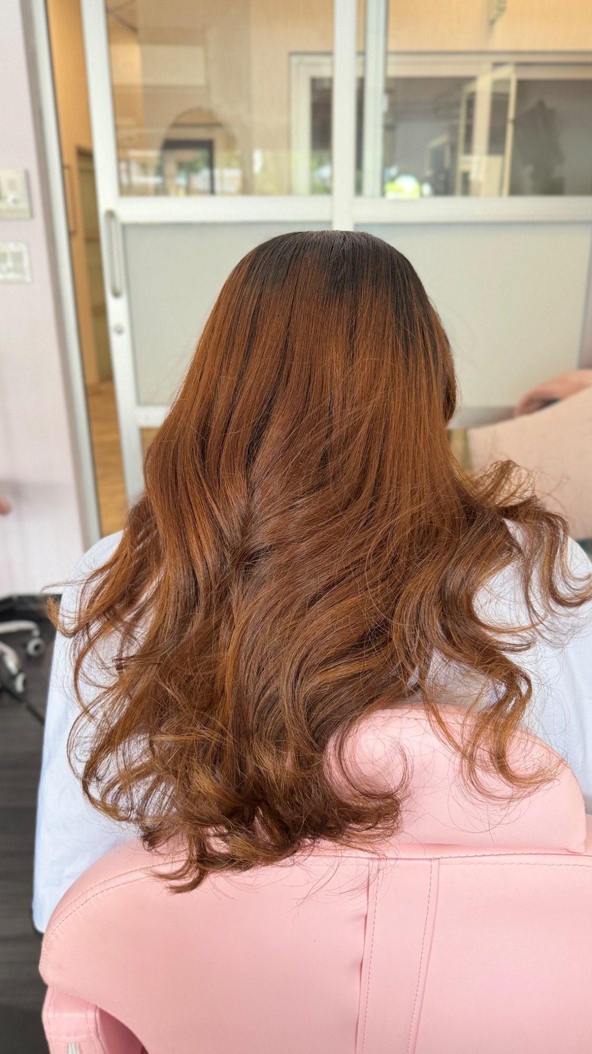 Rear view of warm copper-brown hair with soft flowing layers