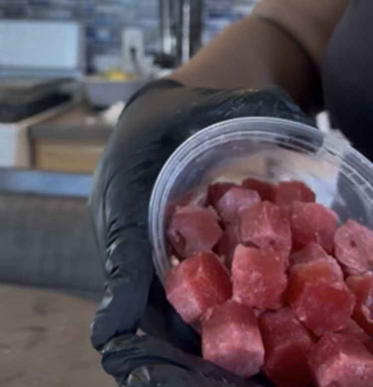 Red hexagon-shaped frozen fruit bites in a cup