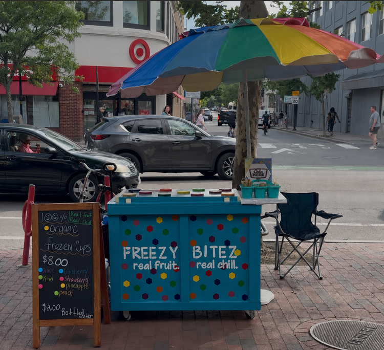 Freezy Bitez cart under a colorful umbrella in Central Square, Cambridge, Massachusetts