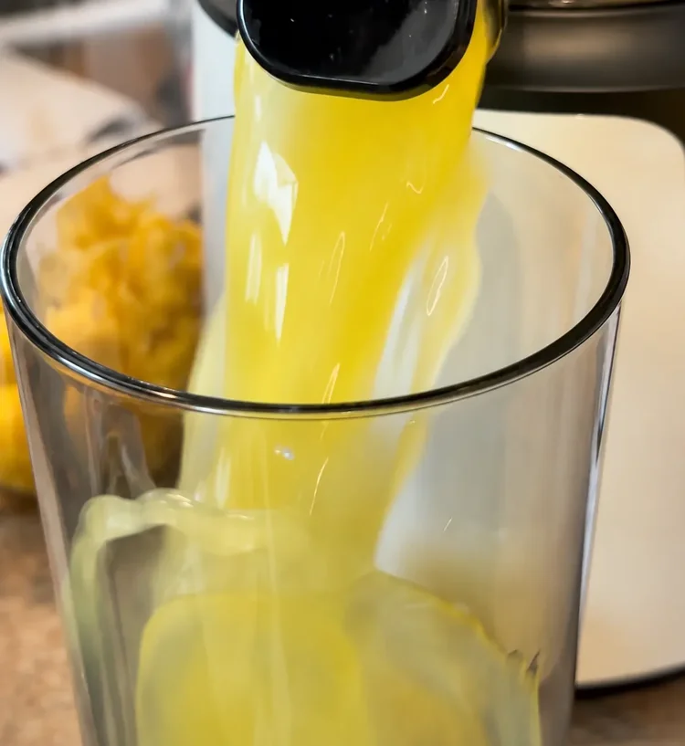 Fresh yellow fruit juice being poured during preparation
