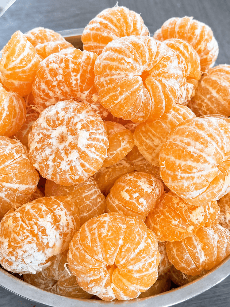 A bowl of freshly peeled citrus fruit