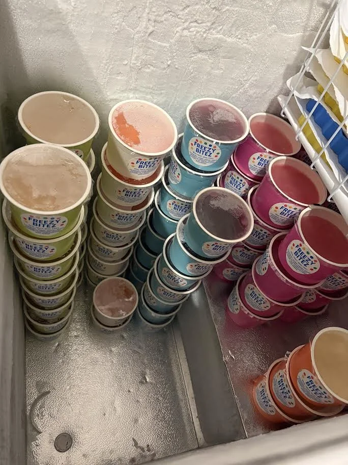 A freezer stocked with colorful Freezy Bitez cups