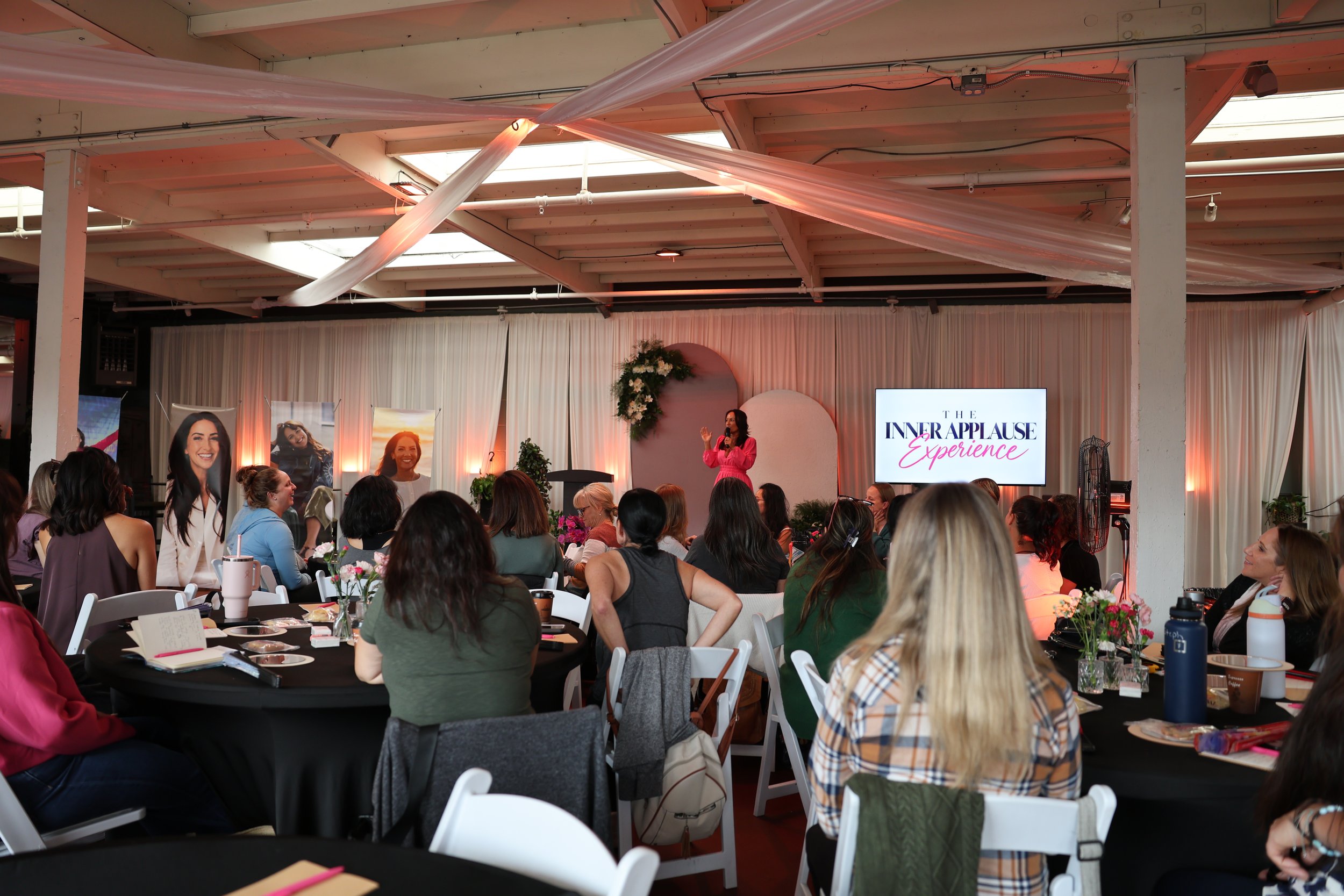 The full room at The Inner Applause Experience, Anette speaking on stage