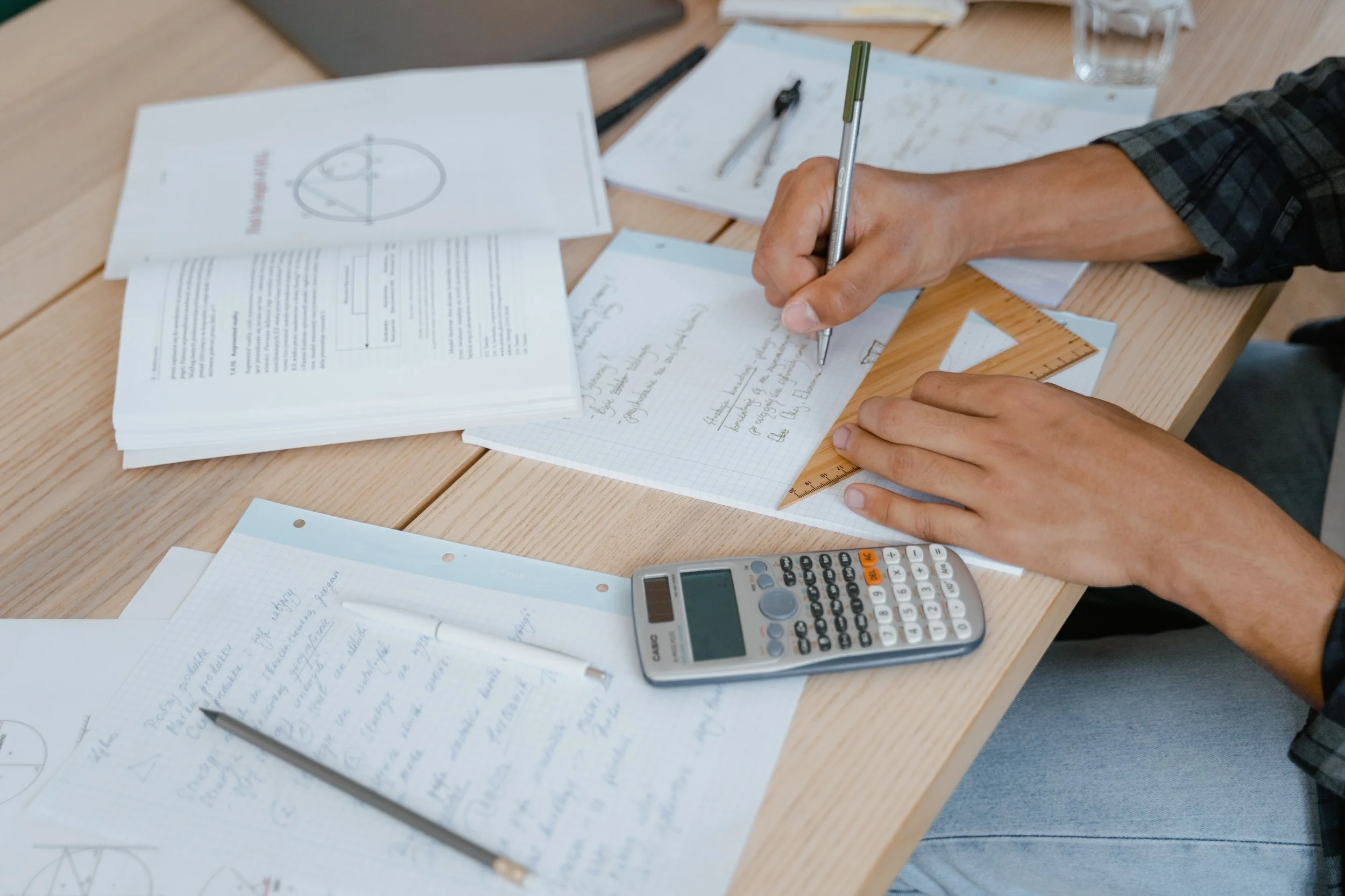 Student working through maths problems with a calculator after a mock exam result