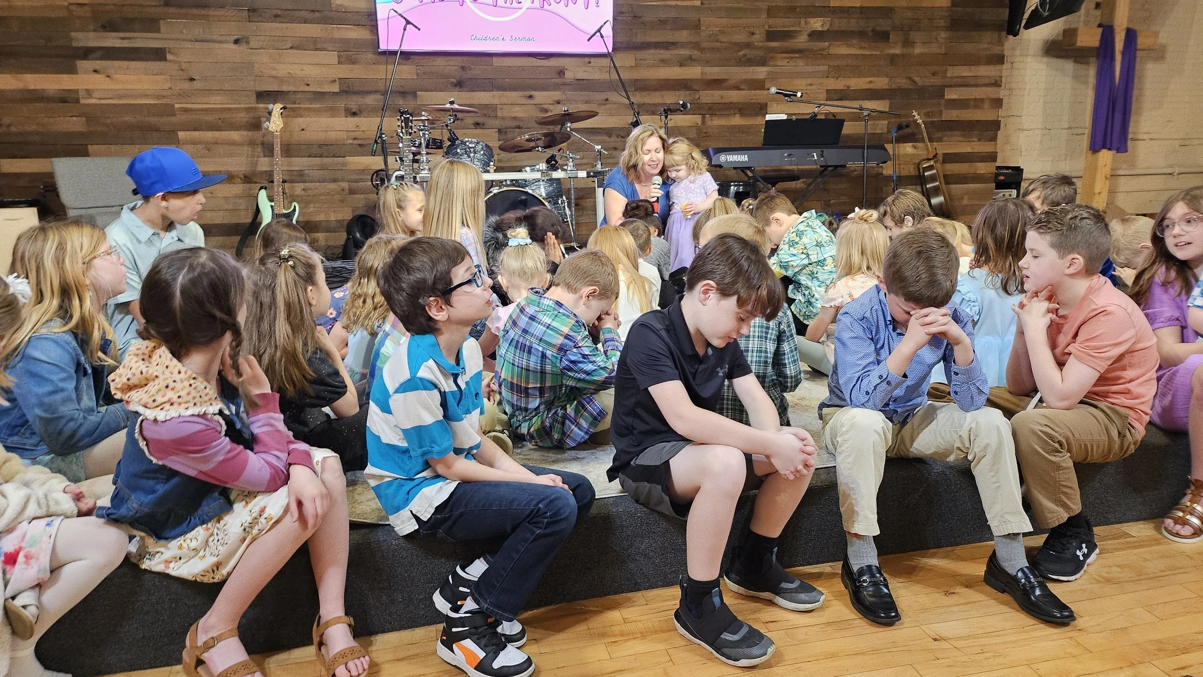 Elaine Pendergrass praying with a child and children