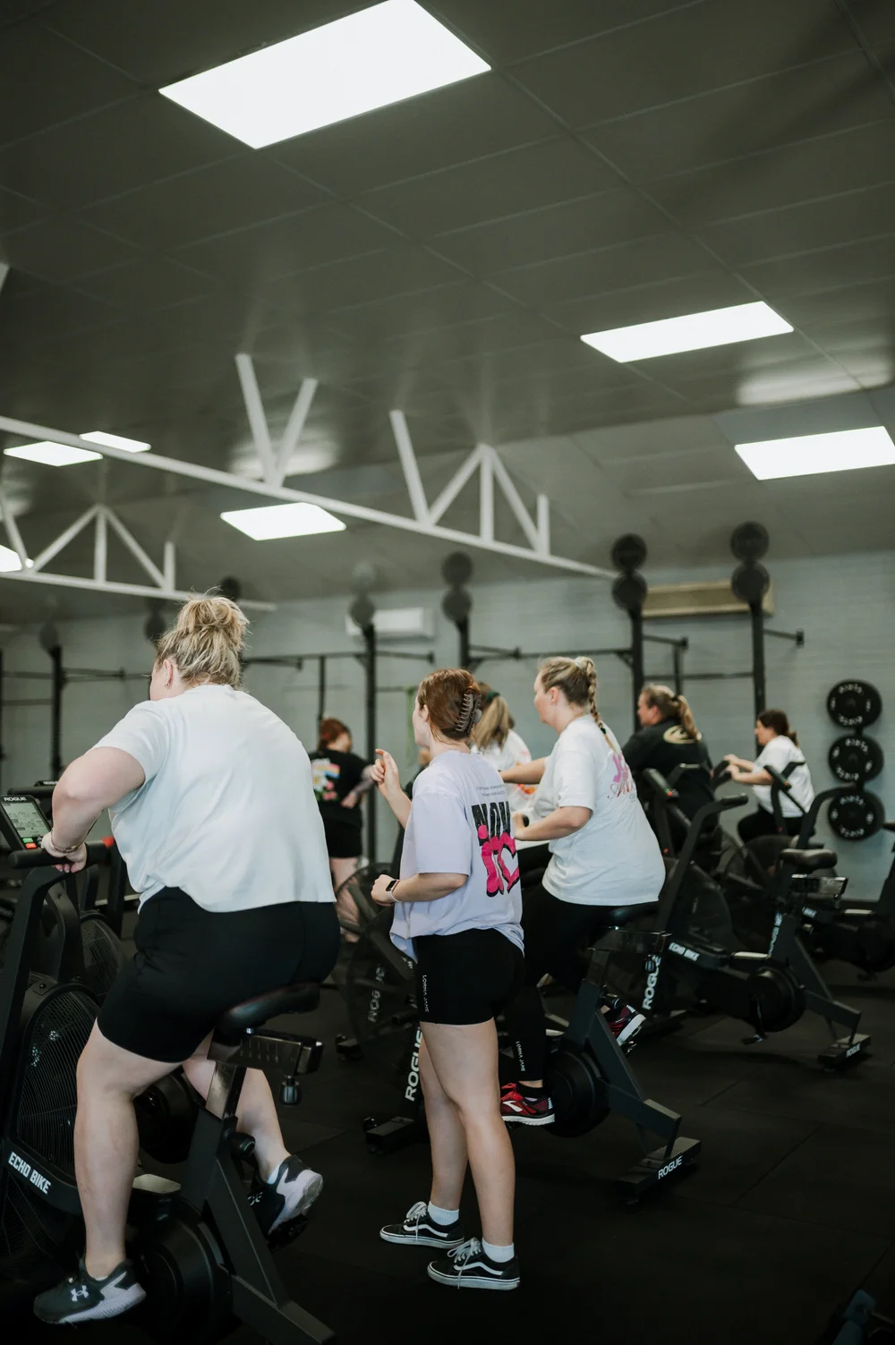 Women training together on echo bikes during a group class