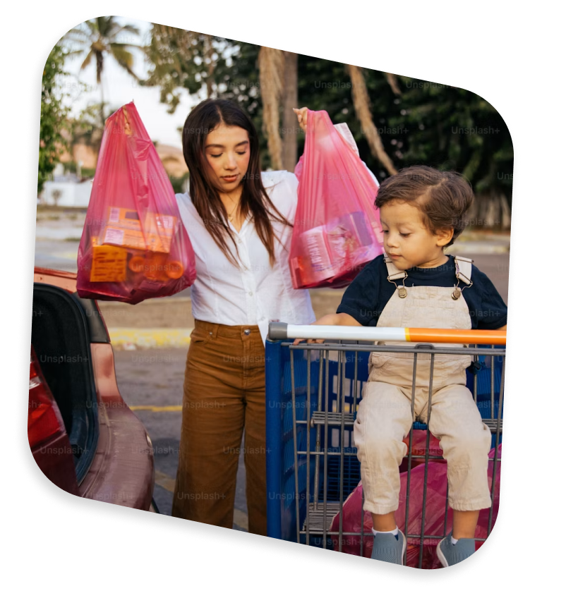 A parent loading groceries with their child