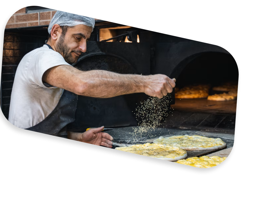 A baker scattering flour over dough