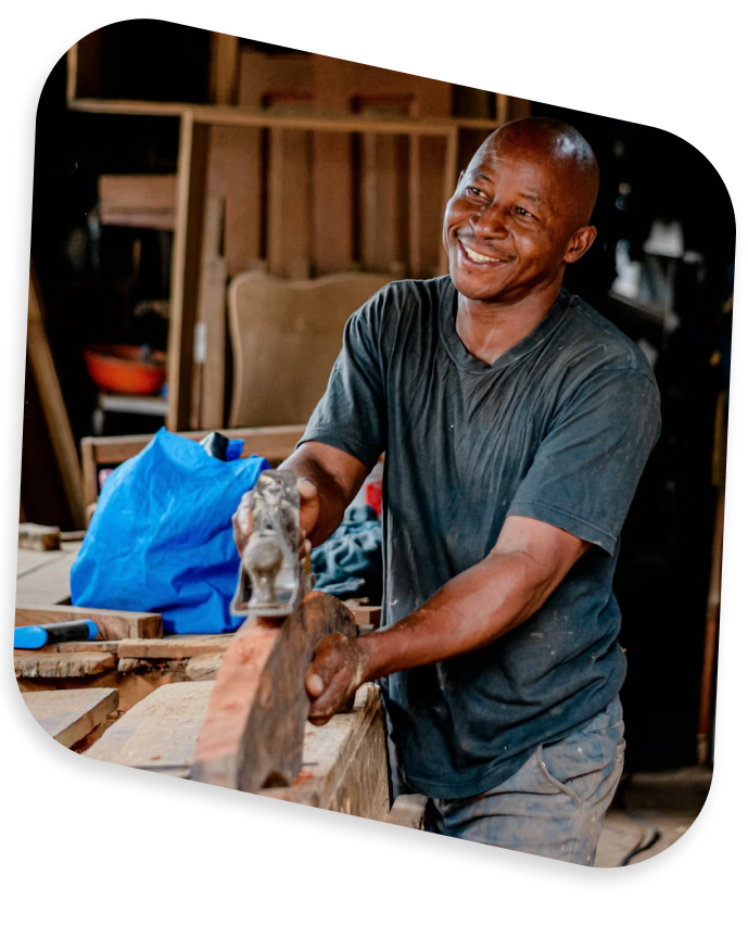 A woodworker smiling at his bench