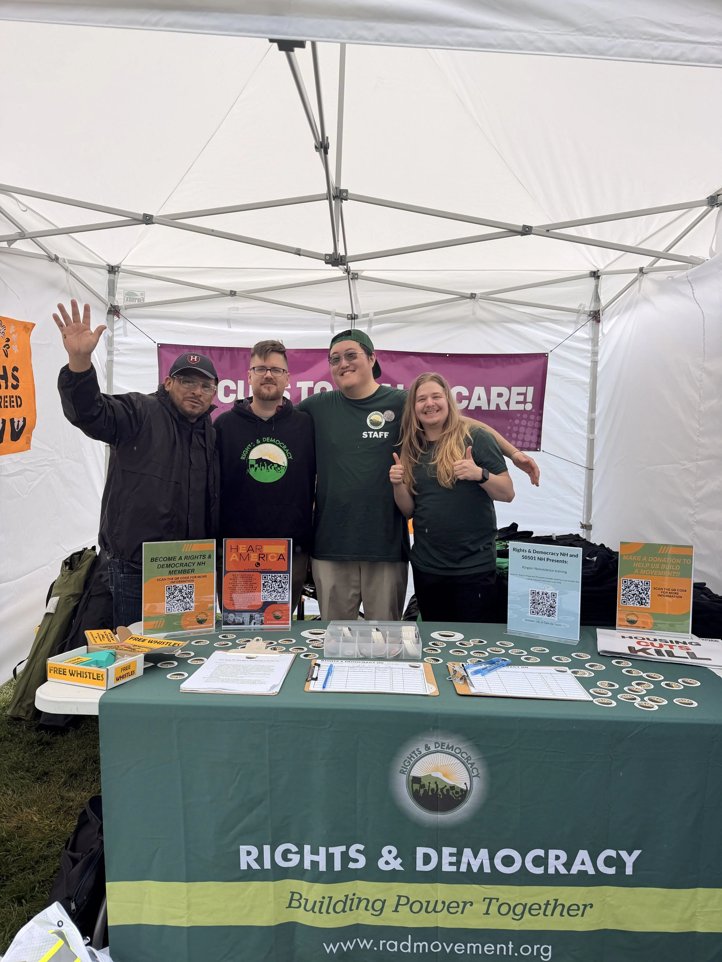 Four people at a RAD-NH table with organizing and membership materials.