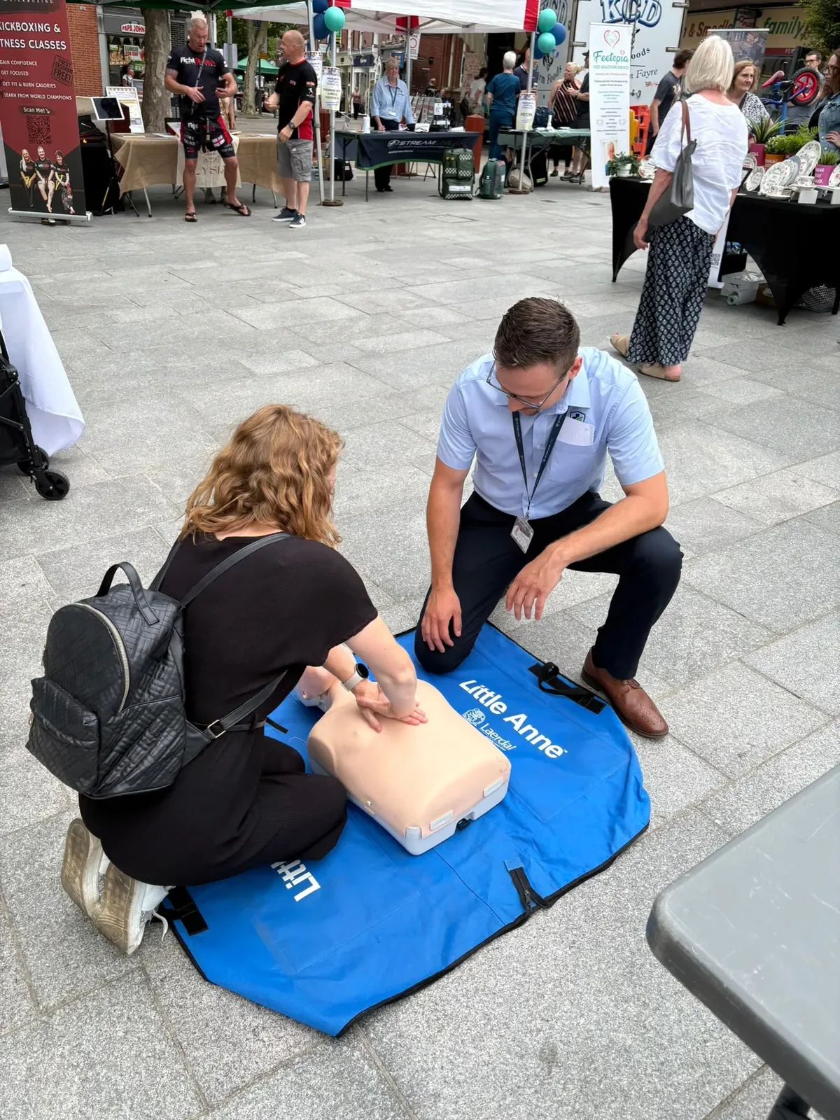 A learner practising CPR on a training manikin with an instructor