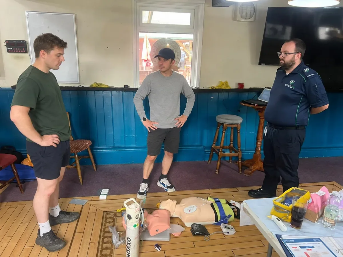 A Streamline instructor with two participants beside medical training equipment