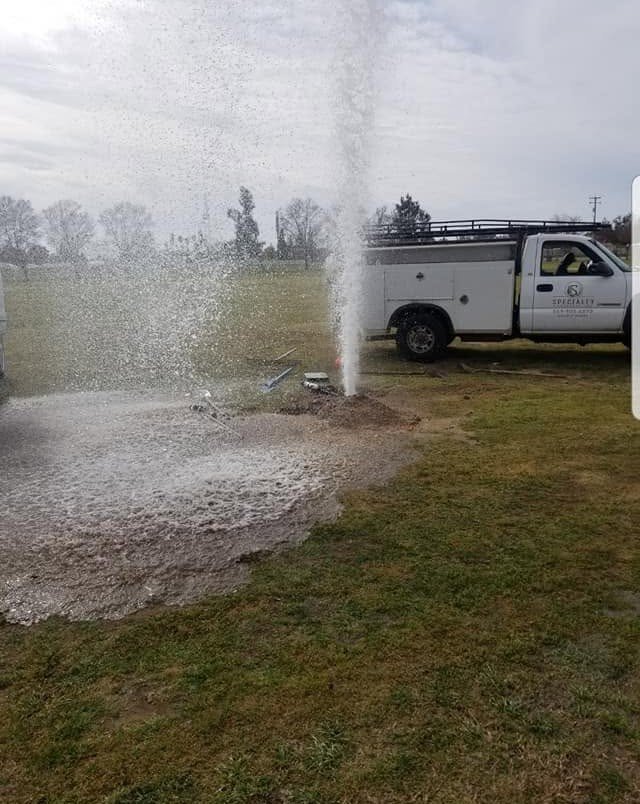 Sprinkler system running beside a Specialty Landscape service truck in Kerman